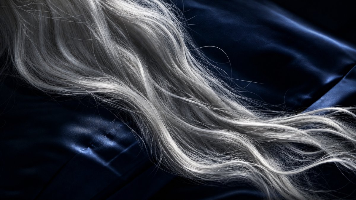 Longs cheveux argentés sur soie marine au clair de lune — sagesse et maturité